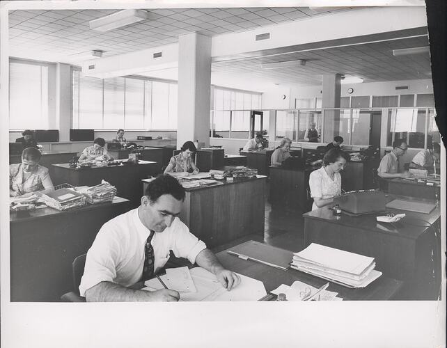 Men and women working in open plan office.