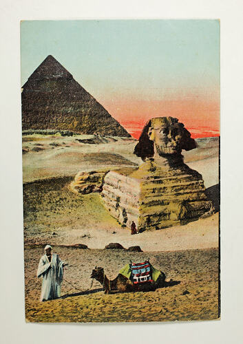 Coloured postcard with sphinx, pyramid, camel and man.