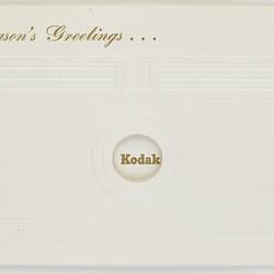 White card with embossed imprint of camera.