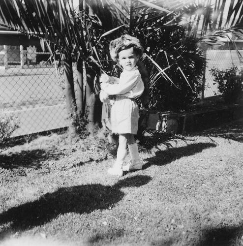 Boy standing in garden.