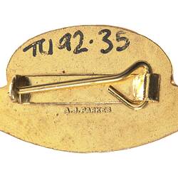 Back of oval metal pin badge.