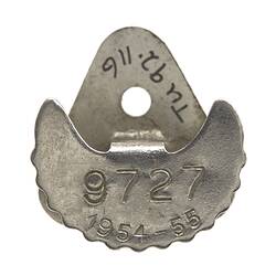 Back of badge with lettering.