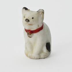 White cat figurine. Black spots and red collar.