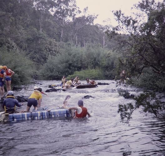 People on rafts in a river.