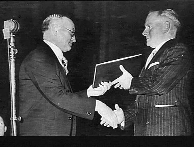 PHOTOS TAKEN AT MELBOURNE TOWN HALL: 21 AUG 1944: DIAMOND JUBILEE SUNSHINE HARVESTER: MR FRED BULT PRESENTING BOOK OF SIGNATURES TO MR C.N. MCKAY