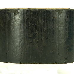 Side view of black briquette.