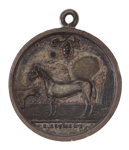 Round silver medal with suspension loop. Horse in centre facing left to a bull.