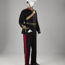 Navy officer's uniform with gold at cuff, epaulettes, belt. Brass buttons. Red/gold collar. White helmet.