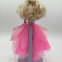 Back of blonde Barbie doll with layered pink and white dress.