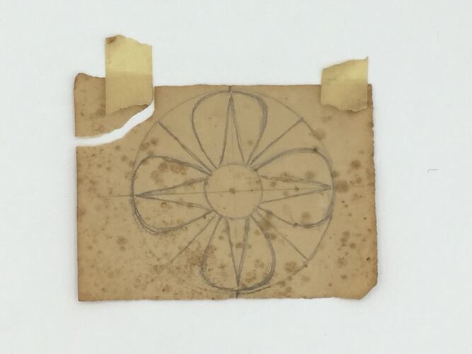 Geometric flower sketched on off-white, worn paper. Torn top left corner.