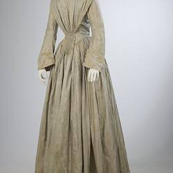 Pale grey striped silk dress with long sleeves and long skirt.