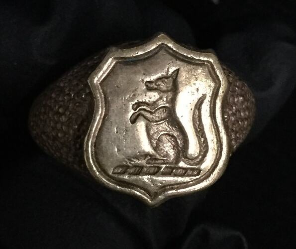 Gilt ring with shield featuring a kangaroo in profile facing left.