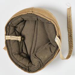 Inside of beige cotton cap, padded, with strap.