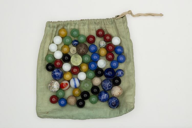 Coloured glass marbles on cloth bag.