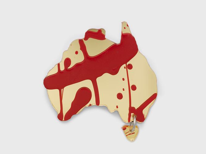 Gold acrylic sheet cut in the shape of Australia, with Tasmania attached via a single link. Splashes of red paint applied over base.