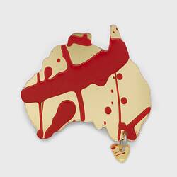 Gold acrylic sheet cut in the shape of Australia, with Tasmania attached via a single link. Splashes of red paint applied over base.