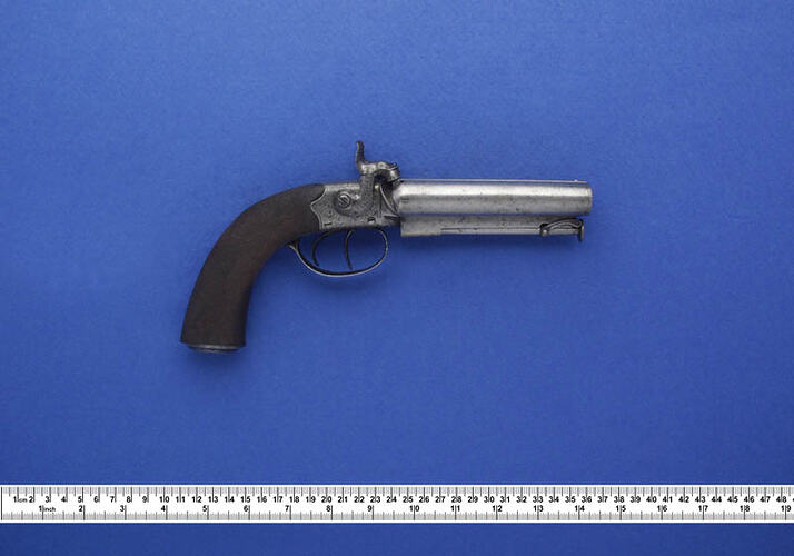 Pistol with silver barrel and curved butt.