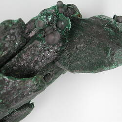 Detail of rounded growths on angular green mineral.