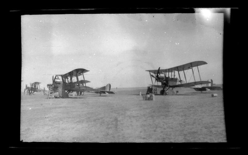 Three military aeroplanes landed in a desert field.