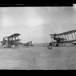 Three military aeroplanes landed in a desert field.