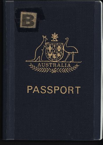 Blue passport cover with gold stamped coat of arms and text 'Australia Passport. 'B' in top left corner.