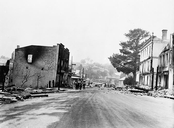 Fire damaged street with ruined buildings either side.