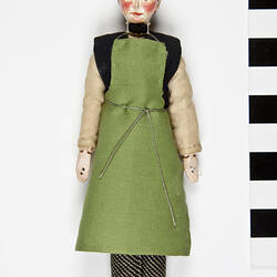 Male servant doll in green apron.