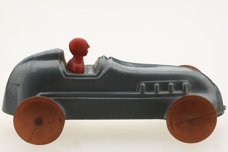 Silver racing car with red driver, right view.