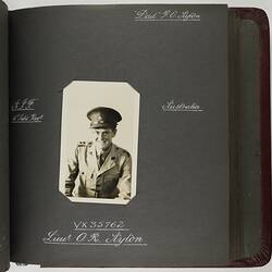 Page with handwritten white text and photograph of servicemen in centre.