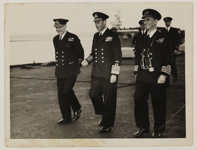 Three men in military uniform walking.