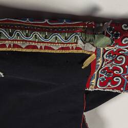 Detail of black fabric with red embroidery.