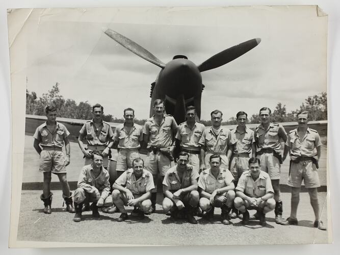 Group portrait of airmen standing in front of aircraft.