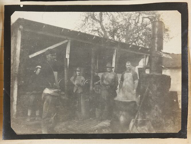 Six men, some in uniform and others wearing aprons.