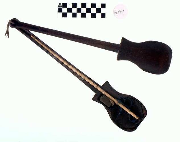 Two part black wooden case with long thin arm and bulbous end. Used to house ivory and brass scales.
