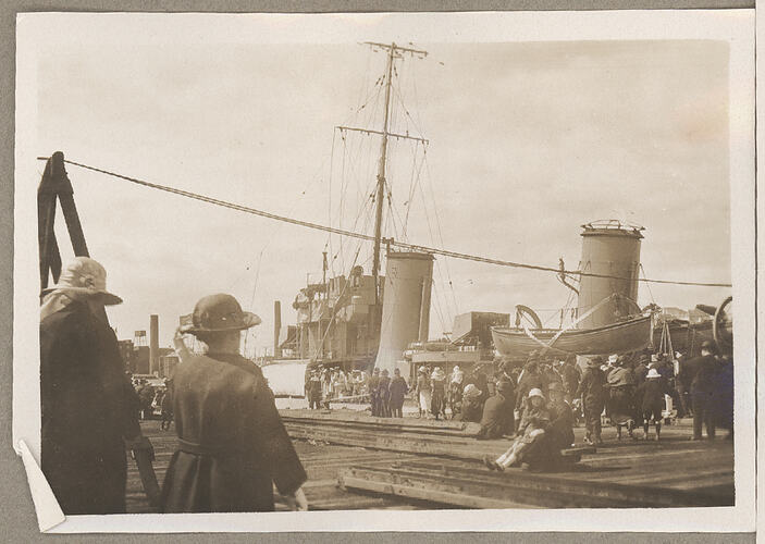 Monochrome photograph of a crowd on a pier.