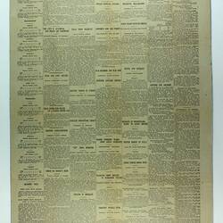 Newspaper page with black printed text on yellow paper.