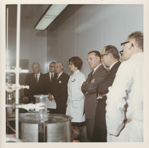 Group of men with female researcher in laboratory.