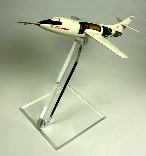 White and black model aeroplane on clear stand.