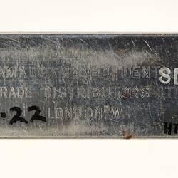 Rectangular metal plate with stamped text.
