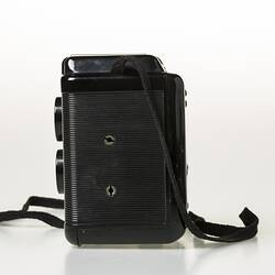 Box camera with black plastic body, black shoulder strap. Back view.