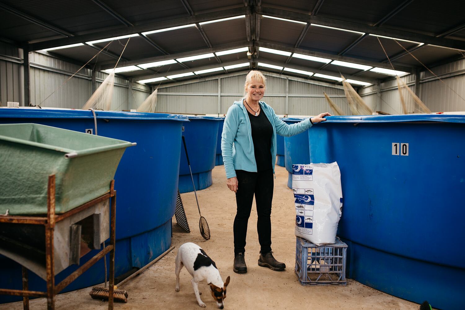 Digital Photograph Trout Farmer Sally Hall Standing by Fish Tanks