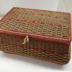 Sewing basket with pink stripes.