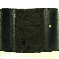 Side view of black briquette.