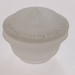 Opaque glass round spice container with lid. Narrower at base.