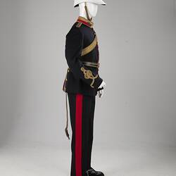 Profile of navy officer's uniform with gold at cuff, sash, epaulettes, belt. Red/gold collar. White helmet.