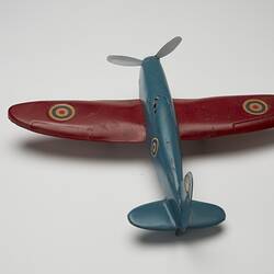 Blue and red toy aeroplane, back view.