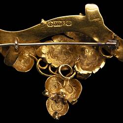 Back of ornate gold brooch with vine leaves on a branch. Horizontal stick pin.