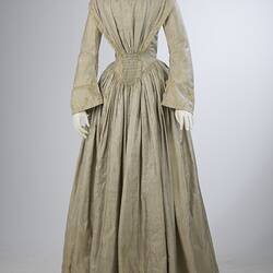 Pale grey striped silk dress with long sleeves and long skirt.