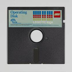 Black floppy disk with hole in centre. Has blue, red and yellow LEGO label along top edge.