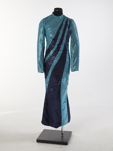 Aqua full-length sequin dress with navy swirls from left shoulder to right hip. Long sleeves, high neckline.